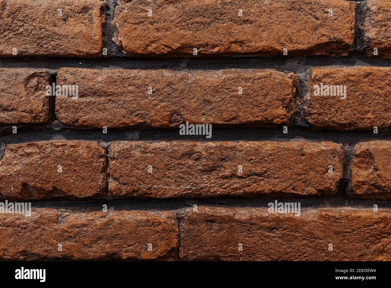 brick wall red dark black seams background for construction. Stock Photo