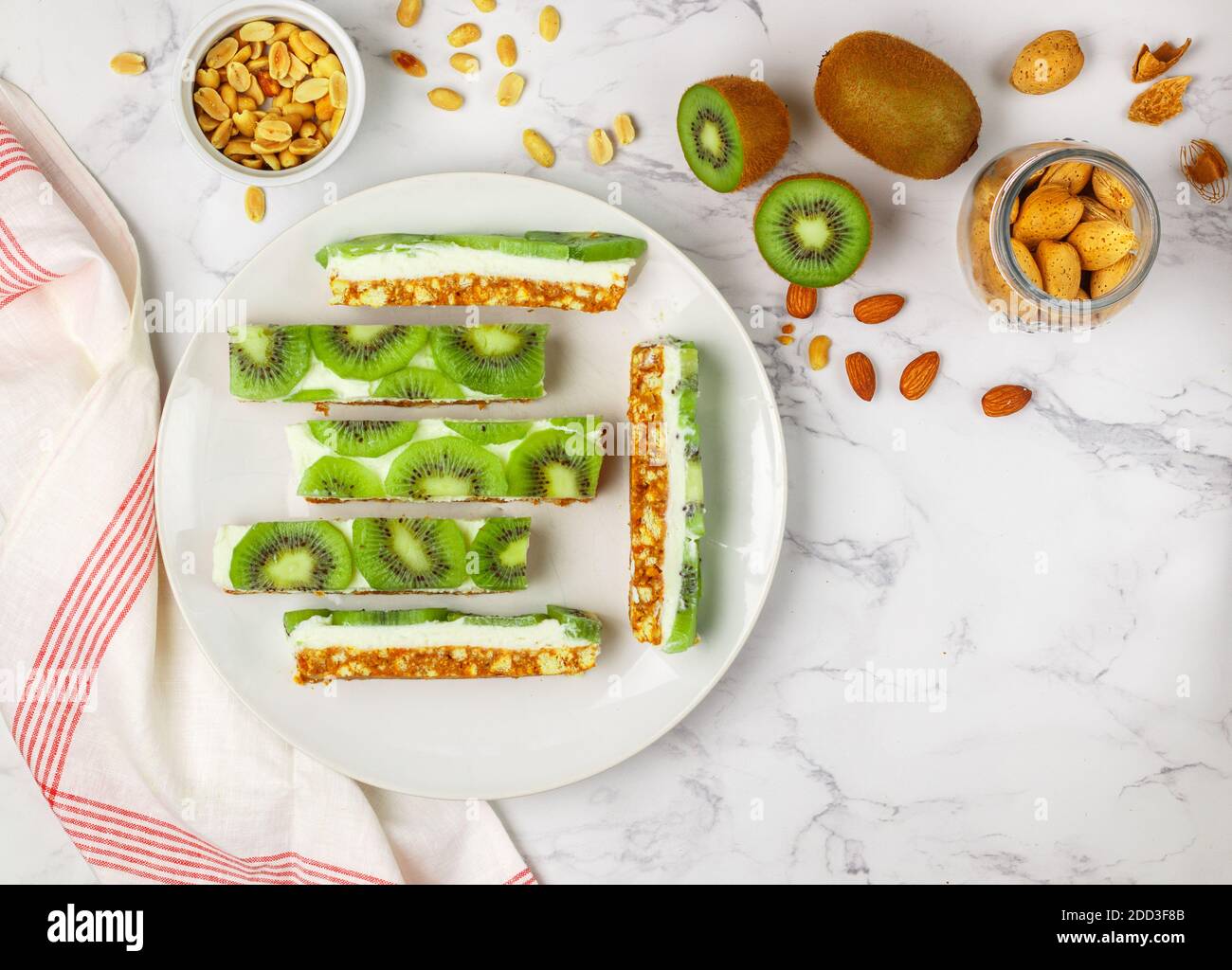Homemade ricotta and kiwi Cheesecake. Delicious shortbread cake with nuts (almonds and peanuts) on a marble background. Healthy and delicious Breakfas Stock Photo