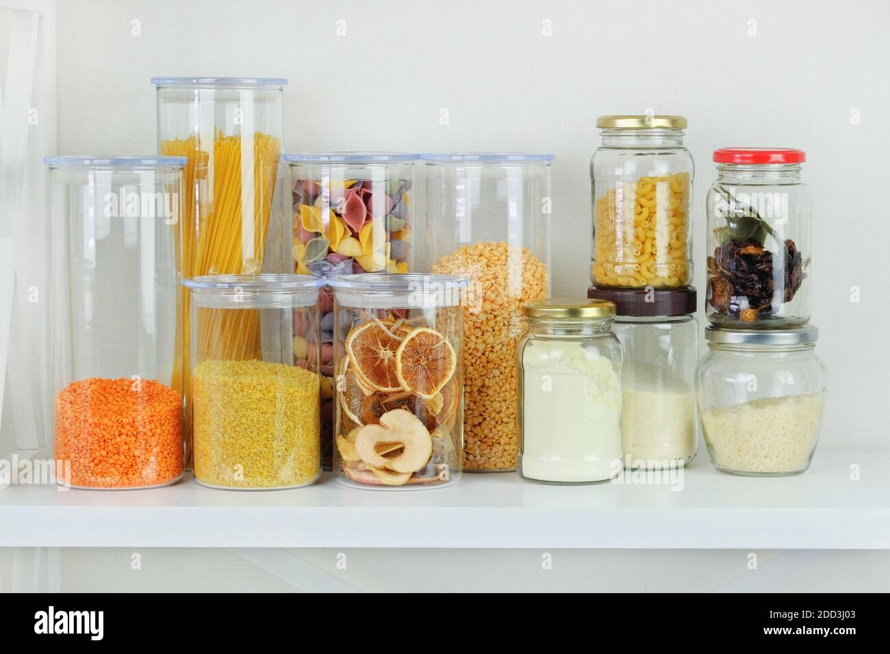 Variety of grain products and pasta in glass storage containers on