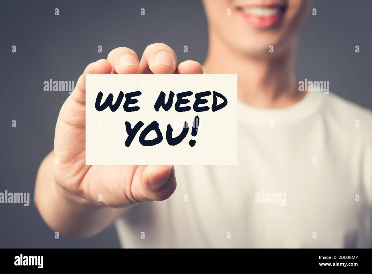 WE NEED YOU! message on the card shown by a man, vintage tone effect Stock Photo
