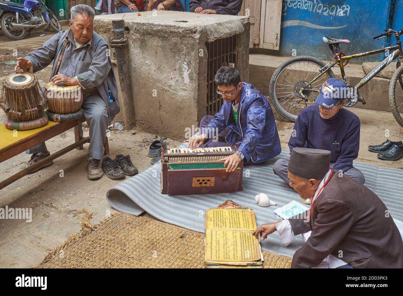 Reading from a prayer book, a Nepalese singer by a small