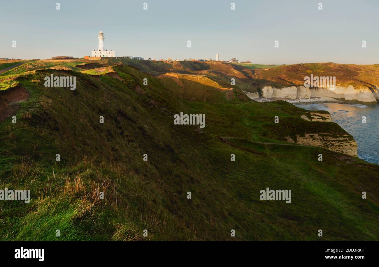View across beautiful English coastline and countryside with sharp cliffs and grass verges towards lighthouse at sunrise at Flamborough, Yorkshire, UK Stock Photo