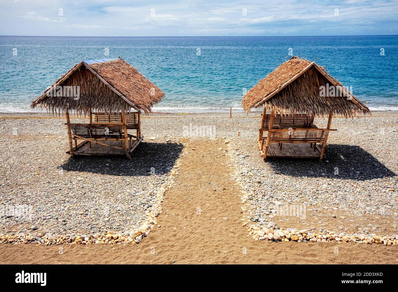 Two bamboo beach huts with nippa roof on a clean empty beach against a blue sea in La Paz, Antique Province, Visayas Islands, Philippines, Asia Stock Photo