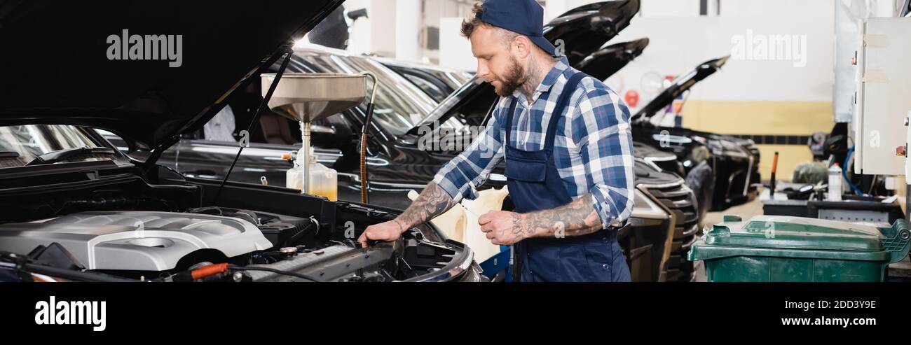 Car Engine Rag technician holding rag while standing near car engine compartment ...