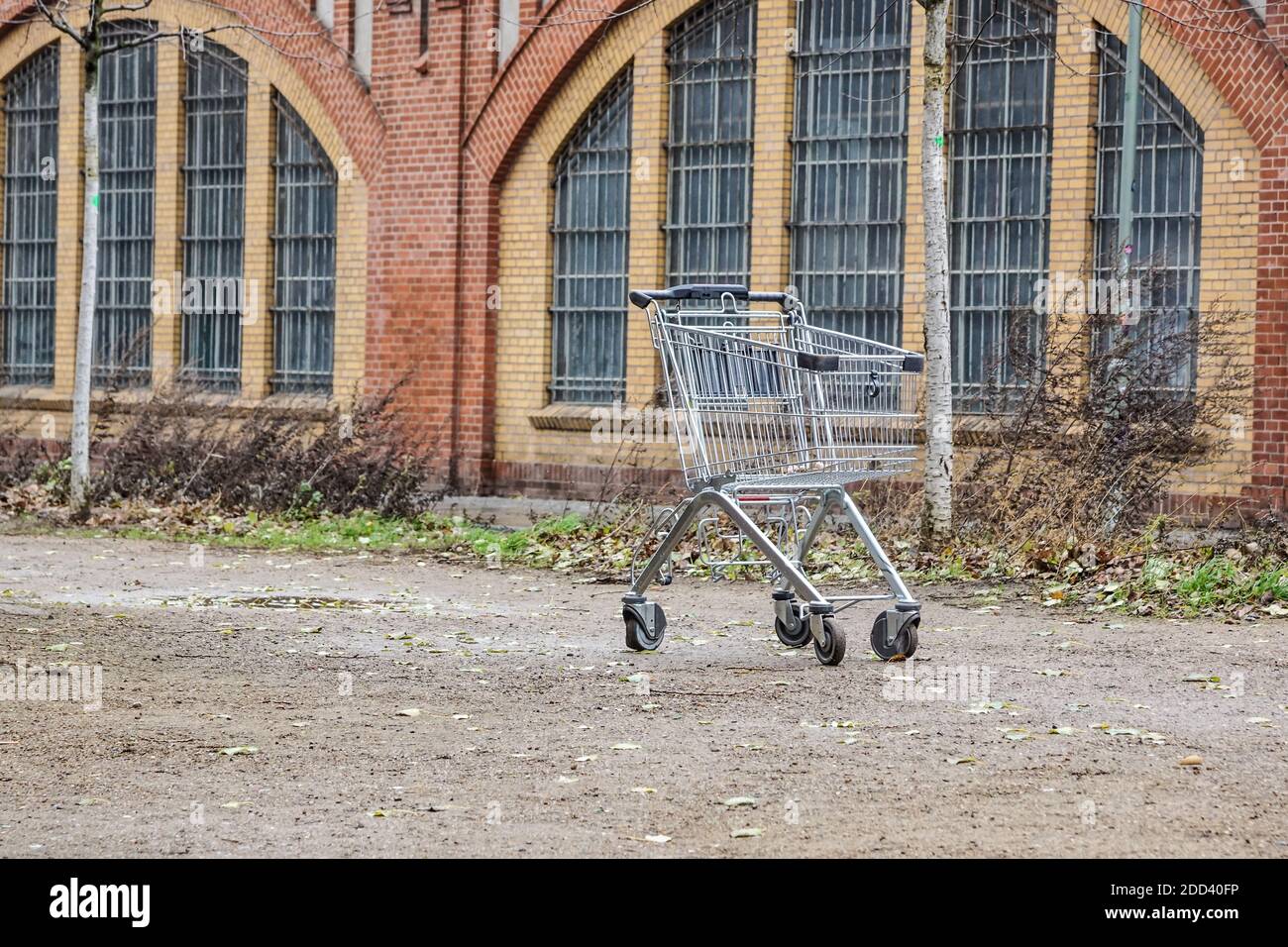 empty shopping cart . trade crisis, abandoned shopping cart in a deserted, empty industrial area. Symbol of the suburbs of abandoned cities or cities Stock Photo