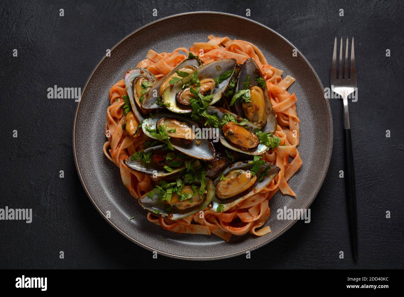 Pasta in tomato sauce with fried mussels, and herbs Stock Photo Alamy