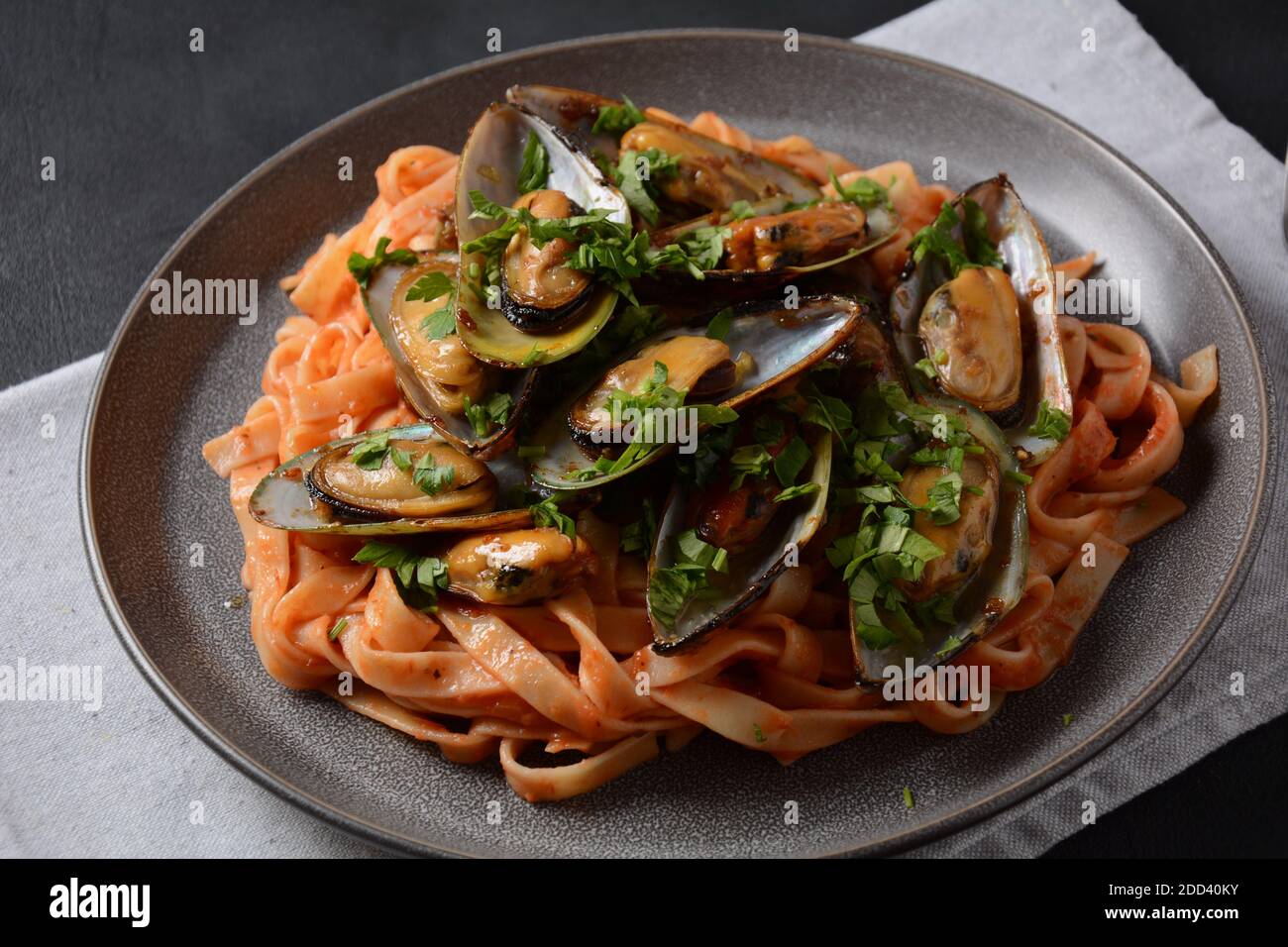 Pasta in tomato sauce with fried mussels, and herbs Stock Photo Alamy