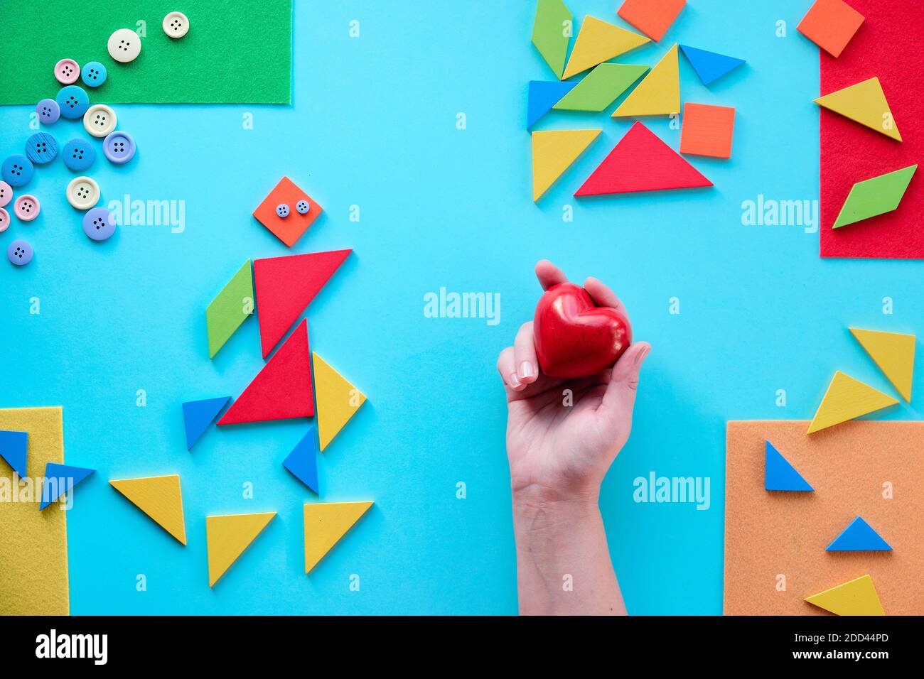 Geometric design for Autism World day with tangram puzzle triangles, pictogram and hand with heart Stock Photo