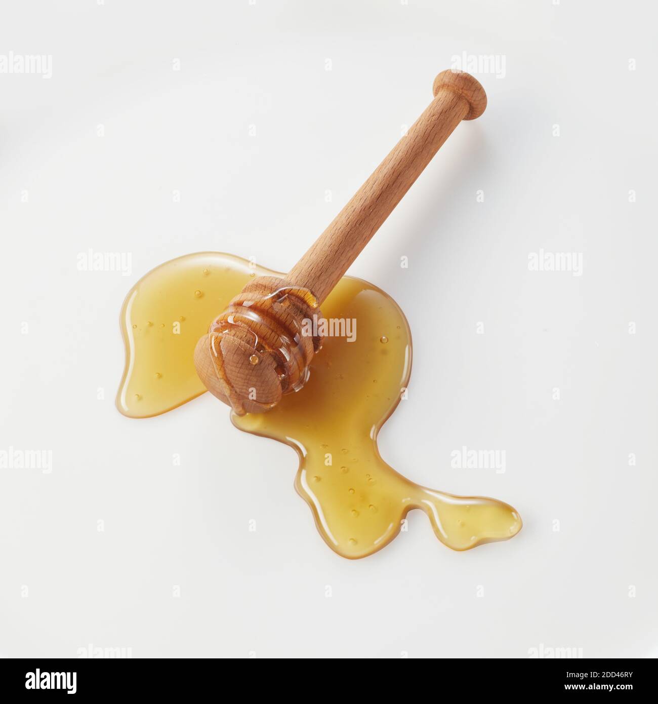 Wooden honey wand with spread of natural golden organic honey on a