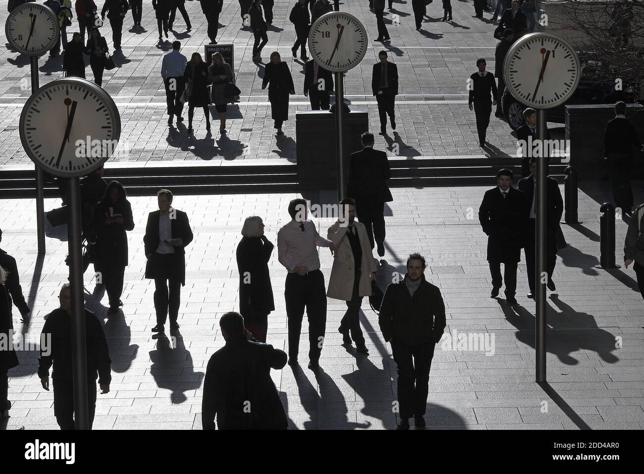 Shadows and silhouettes of pedestrians walking through Reuters Plaza, Canary Wharf, London, UK Stock Photo