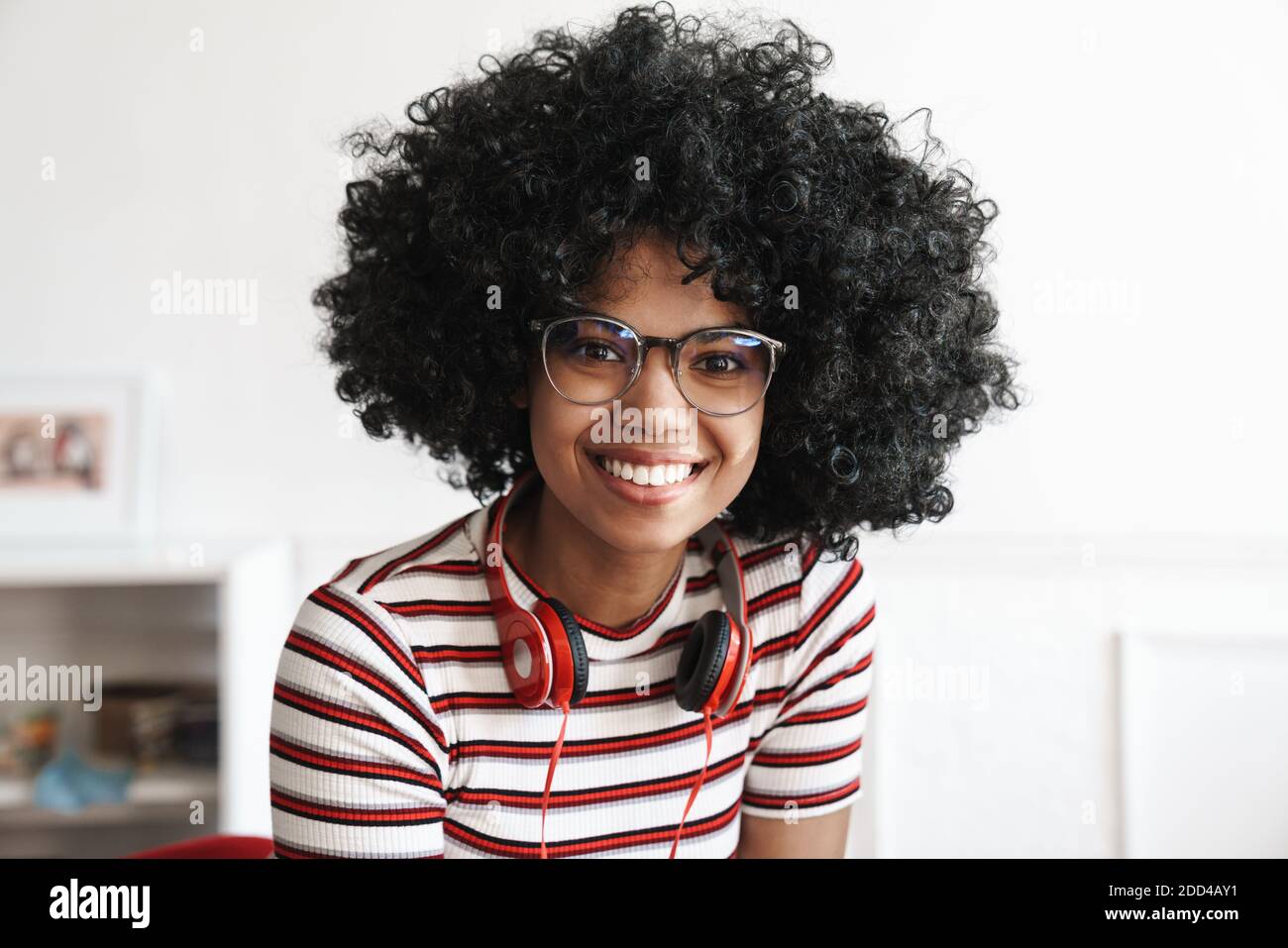 Happy african american student girl with headphones smiling at camera ...