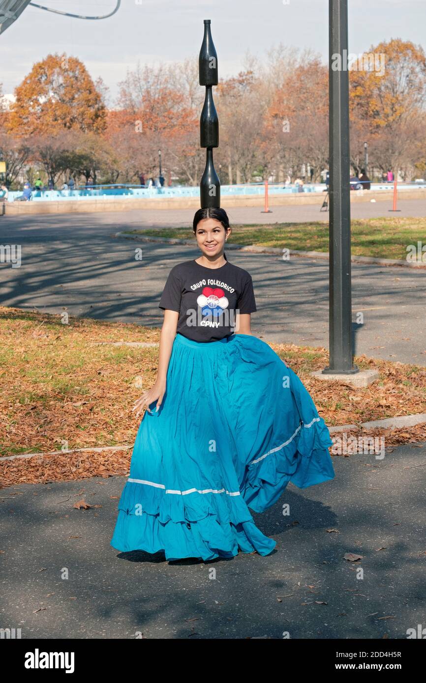 A Paraguayan American dancer rehearses in Flushing Meadows Corona Park while balancing 3 wine bottles on her head. Stock Photo