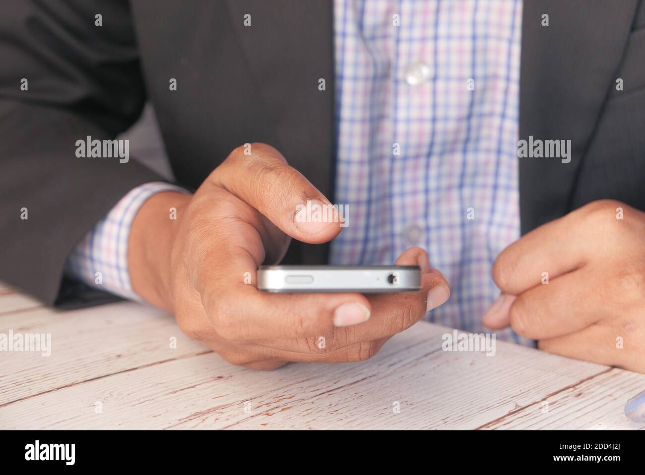 man in suit using smart phone on office desk  Stock Photo