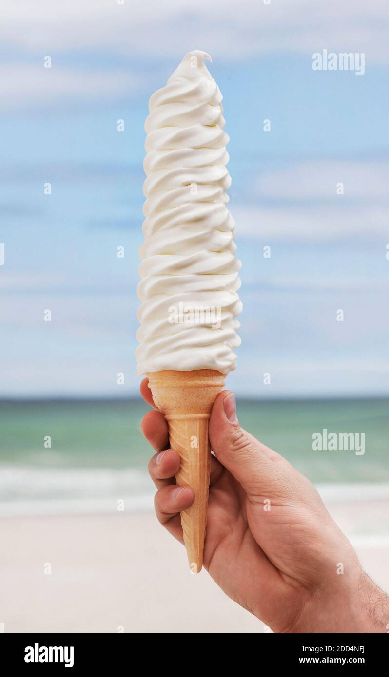 Hand holding very tall soft serve ice cream Stock Photo