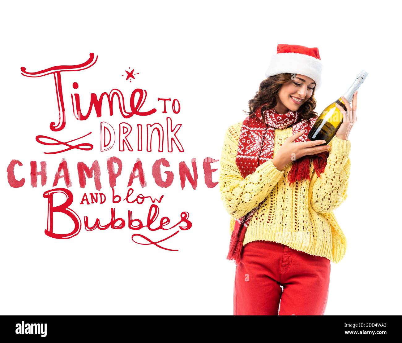 joyful young woman in santa hat looking at bottle of champagne near time to drink champagne and blow bubbles lettering on white Stock Photo