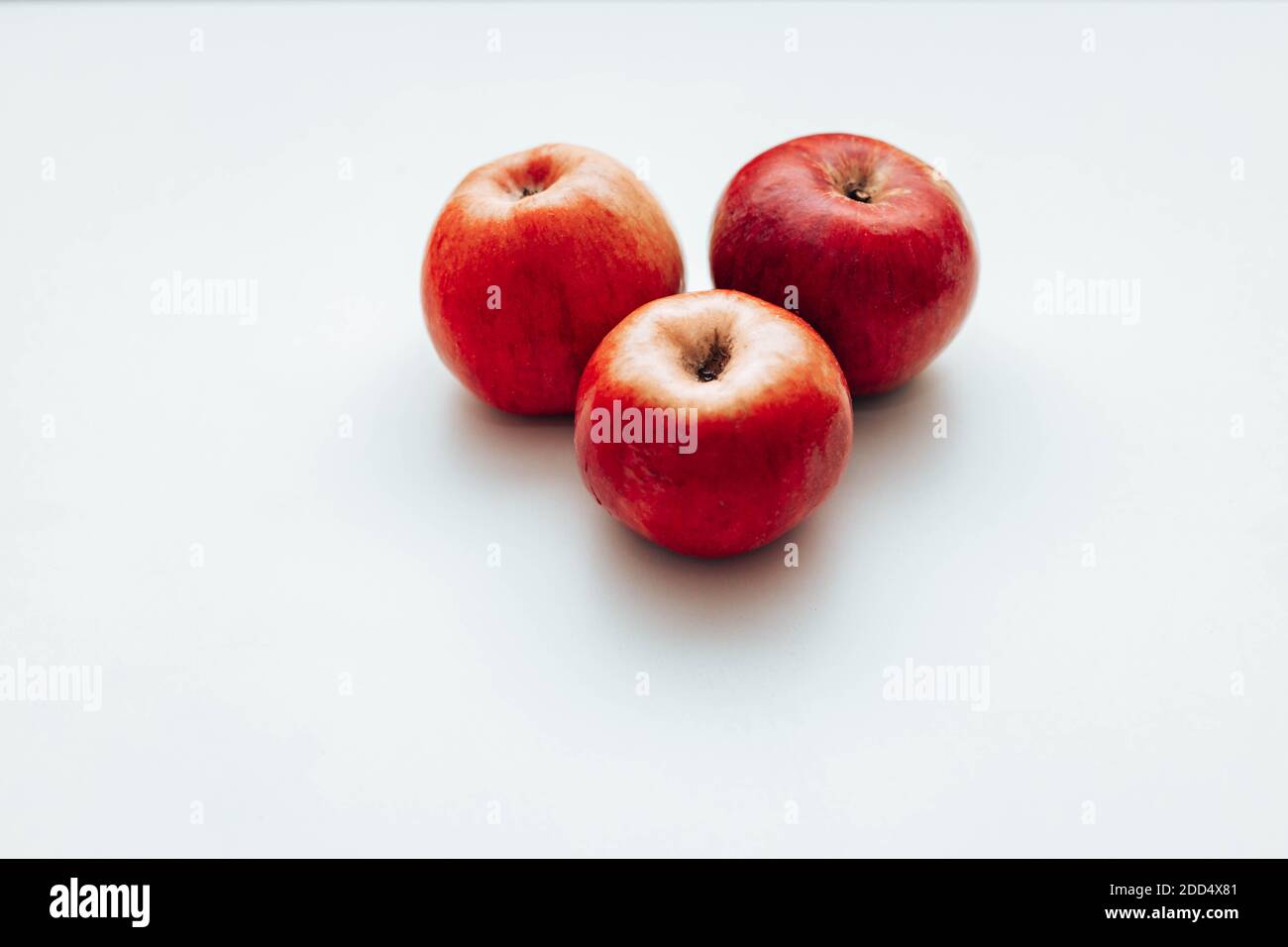 Three red juicy apples on white table. Space for text Stock Photo