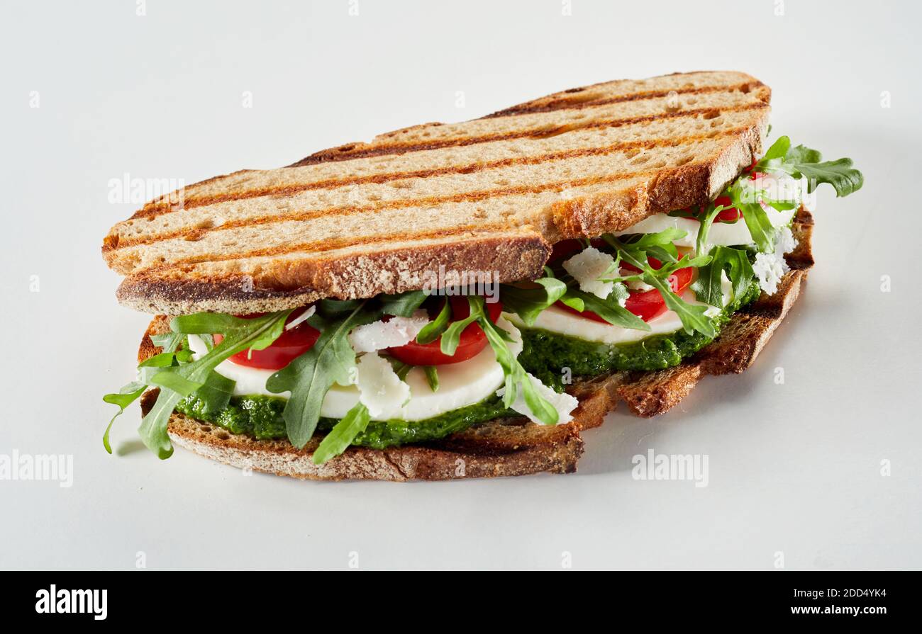 Healthy rye bread sandwich with pesto and mozzarella cheese with rocket greens viewed side on