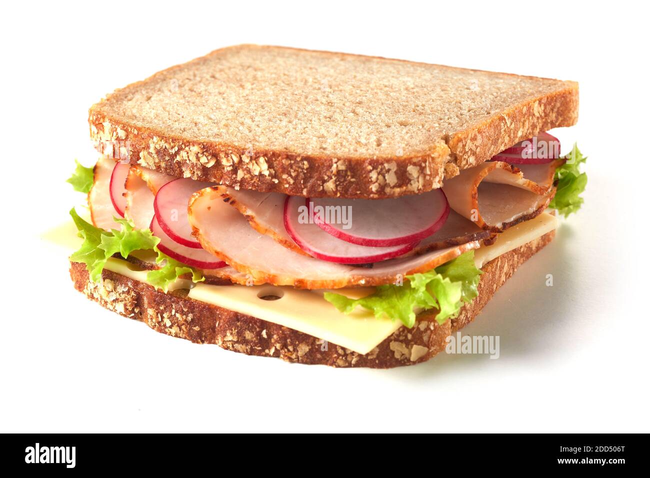 Wholegrain sandwich with cheese and ham trimmed with fresh lettuce and radish in a low angle side view on white Stock Photo