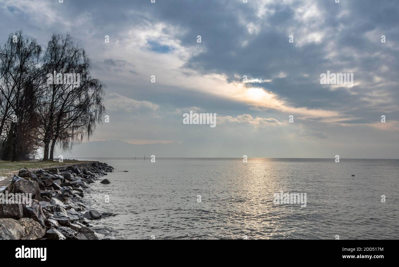 Beautiful winter sunrise on the lake Leman, near the Lausanne city. Winter and snow time Stock Photo