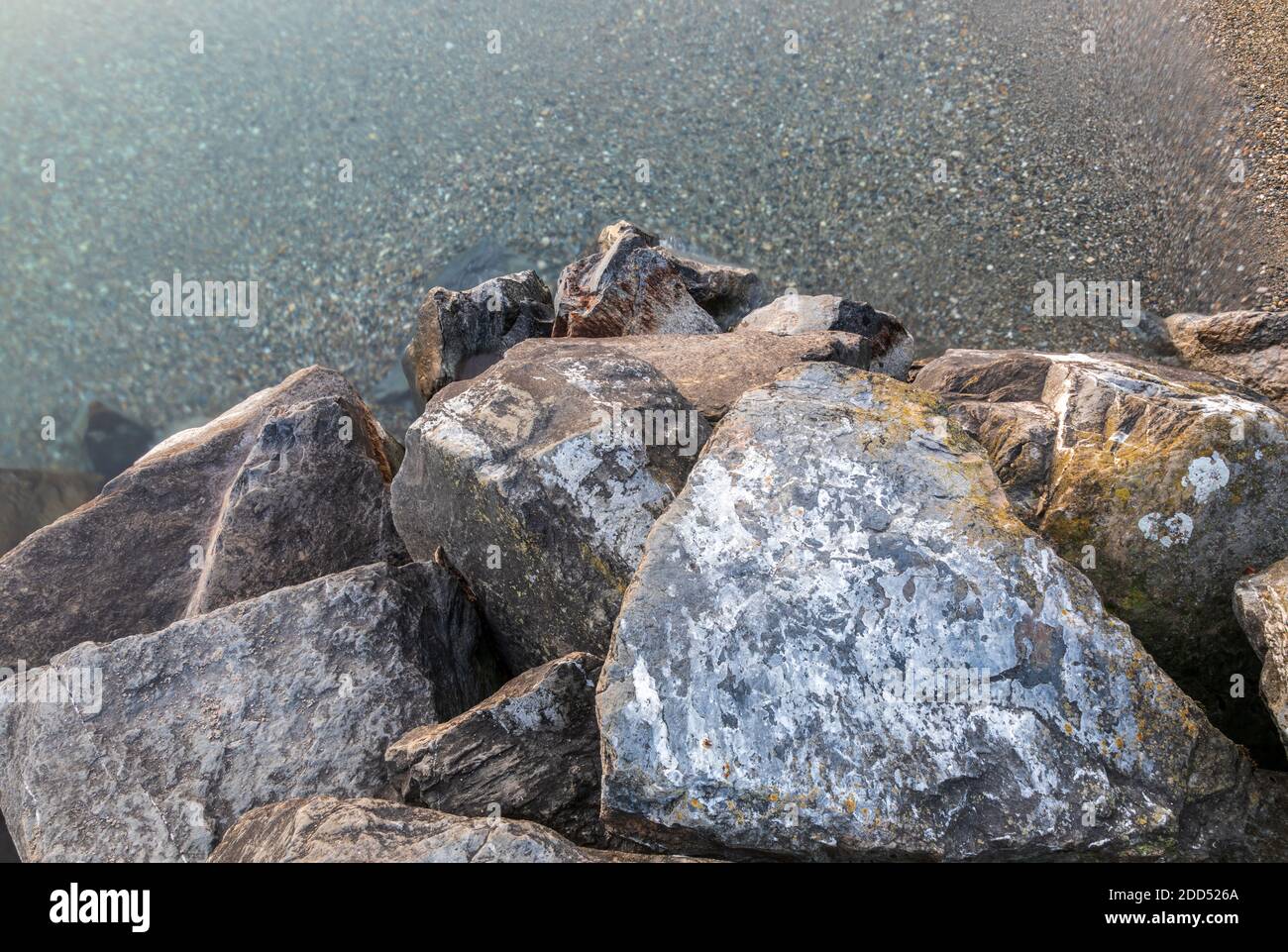 Beautiful waterscape. Dreamy natural background with lake shore, rocks and waves. Long exposure. Lake Leman, Lausanne, Switzerland Stock Photo