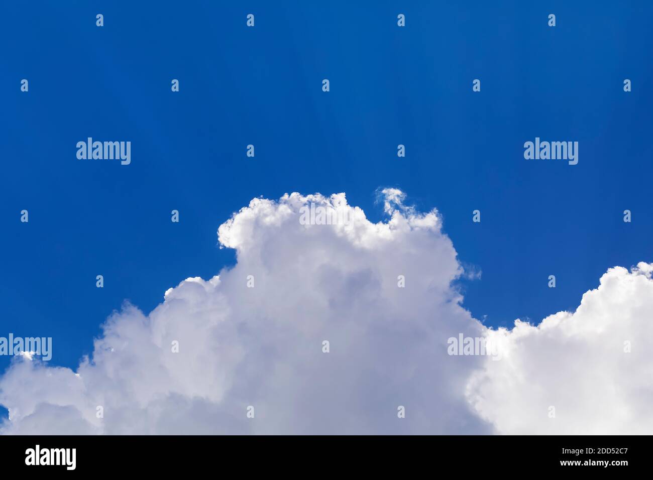 Dramatic white clouds float in the blue sky. Stock Photo