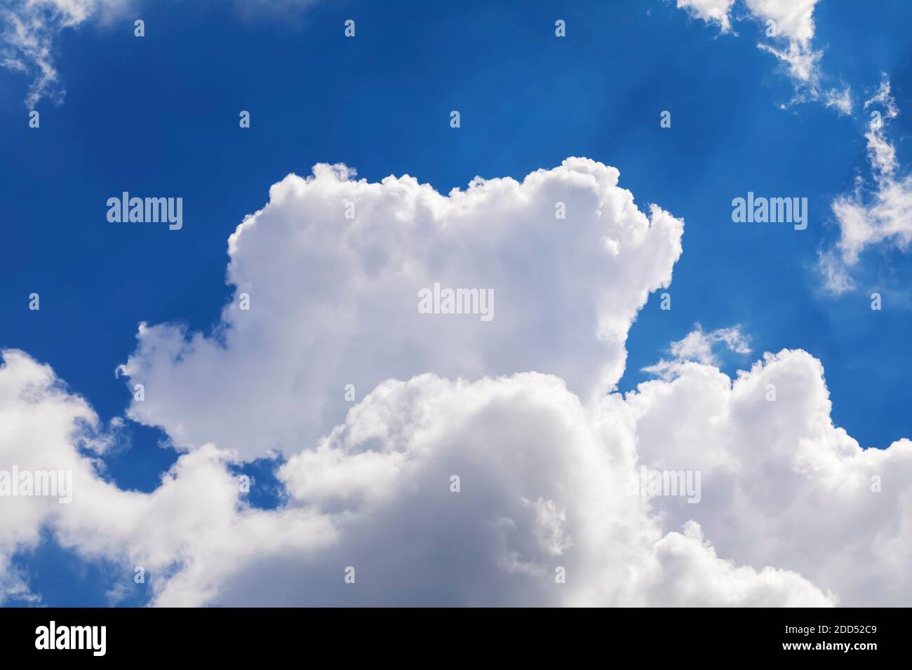 Dramatic white clouds float in the blue sky. Stock Photo