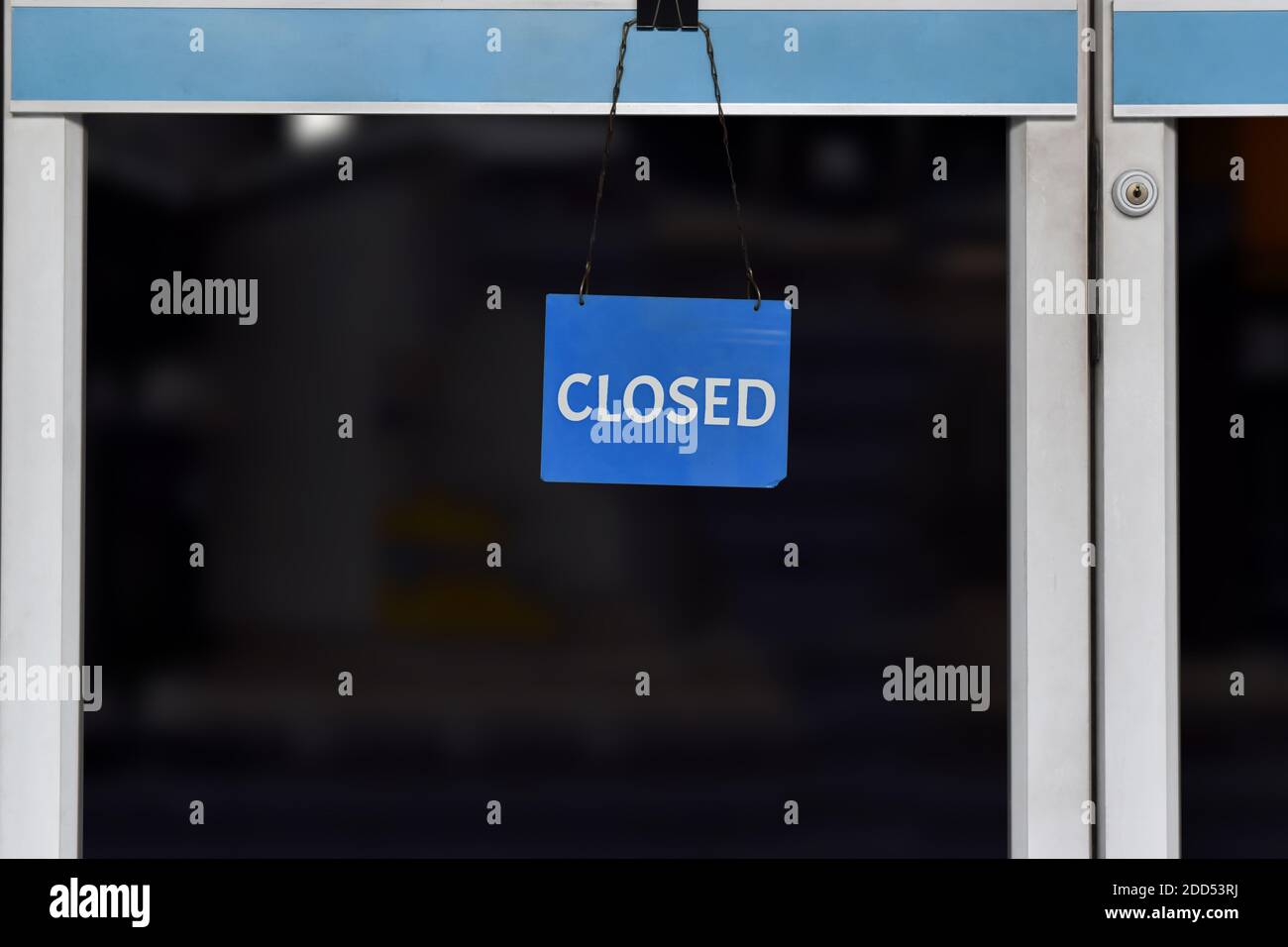 A sign 'closed' hanging on the glass door in a shop, Close due to financial difficulties and economic crisis. Stock Photo