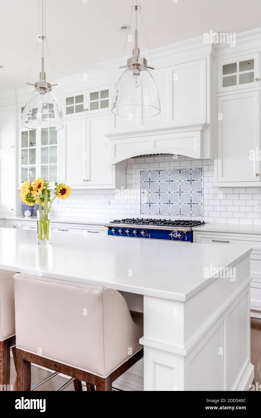 A beautiful kitchen detail shot looking from the island towards the oven and white kitchen cabinets. Stock Photo