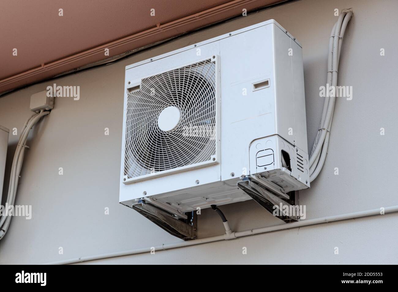 Outdoor Air conditioning unit mounted on wall used for cooling space Stock Photo