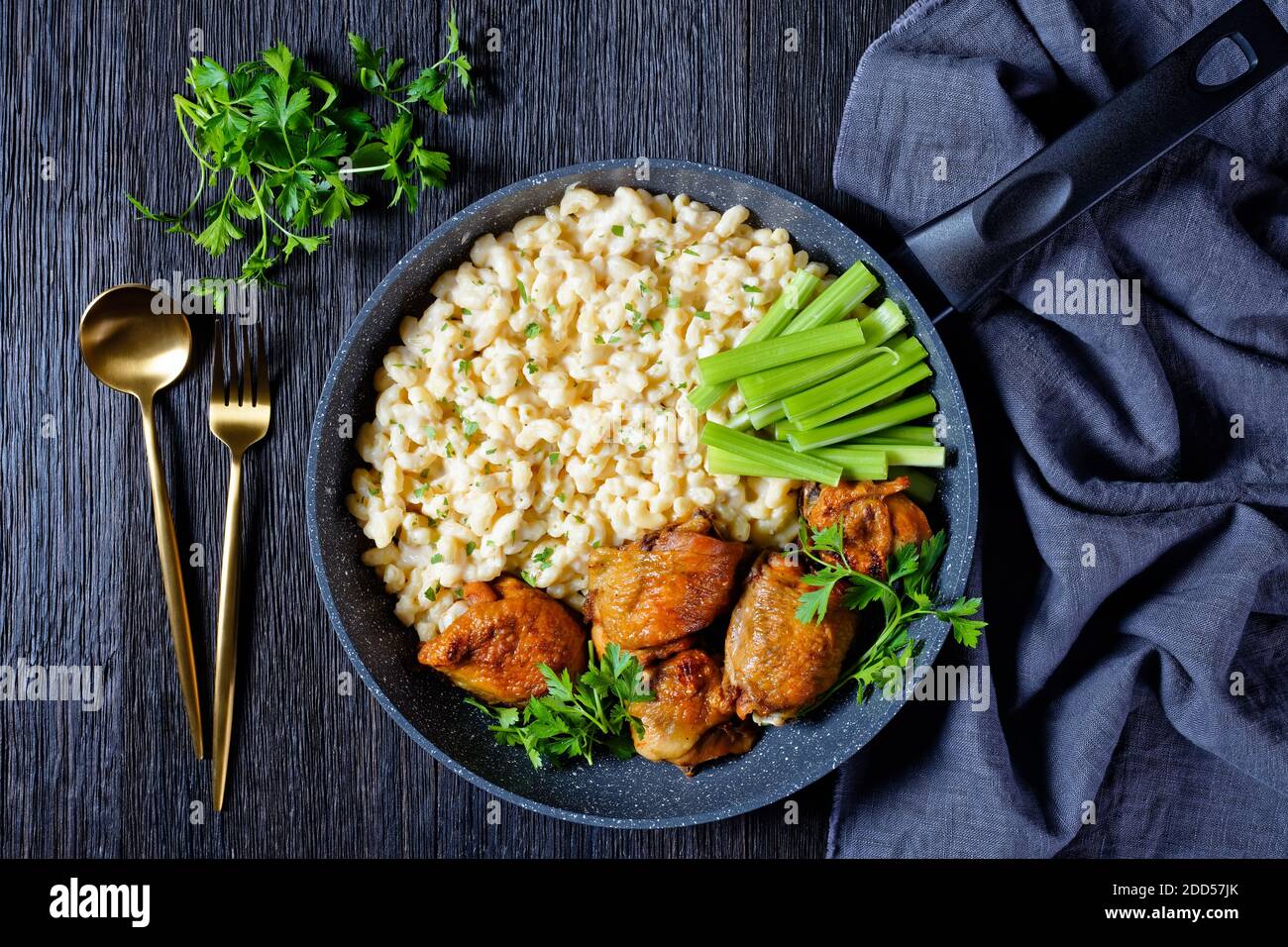 roast chicken thighs with mac and cheese, celery sticks in a skillet on