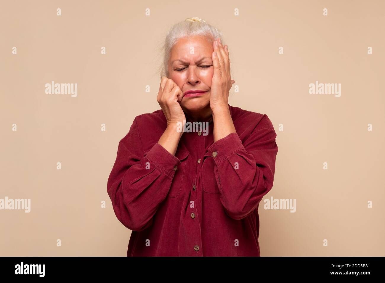 Senior woman suffering from headache desperate and stressed because of pain and migraine. Studio shot Stock Photo