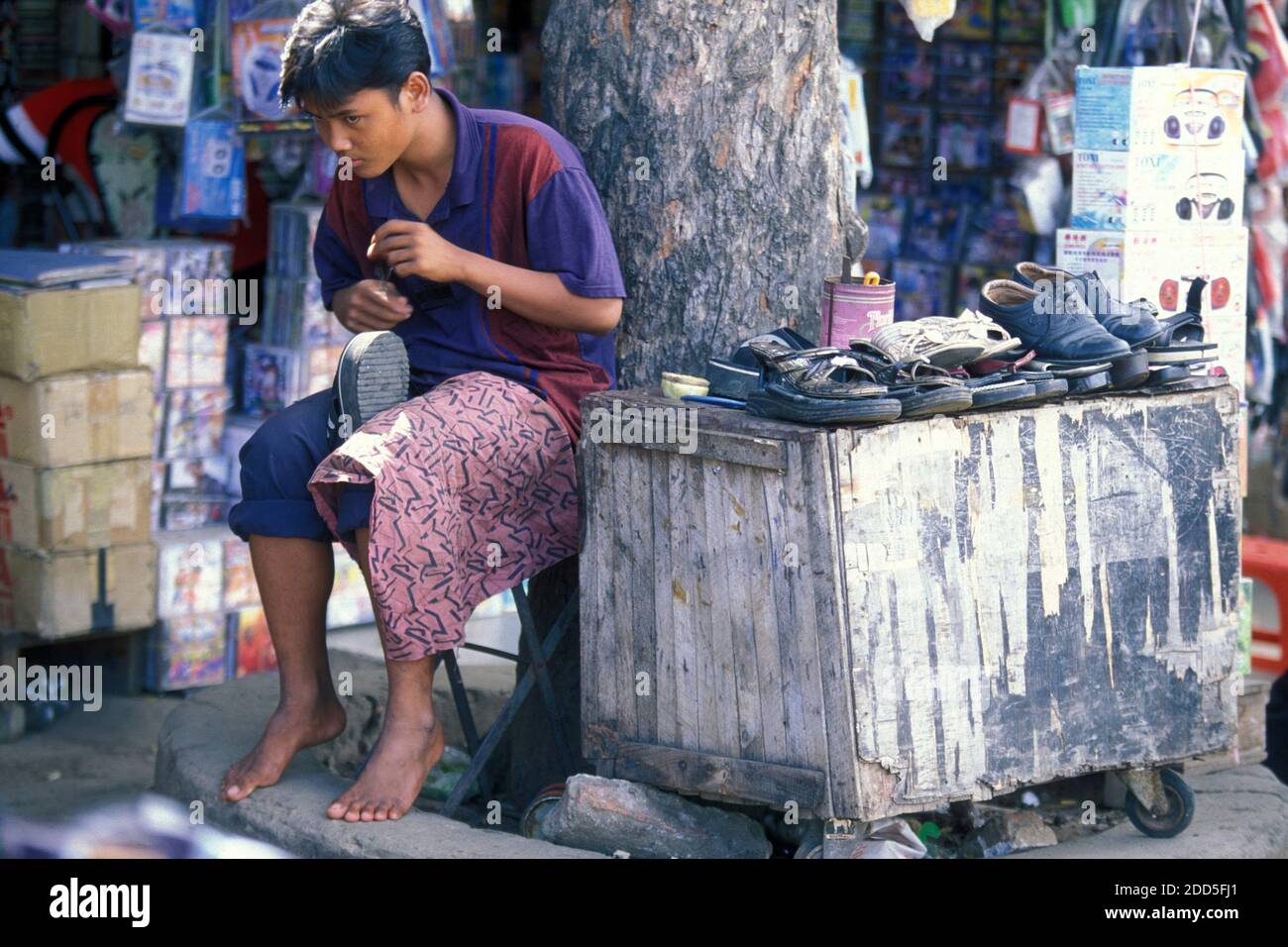 a shoe maker at the central market or Psar Thmei market in the city of Phnom Penh of Cambodia.  Cambodia, Phnom Penh, February, 2001, Stock Photo