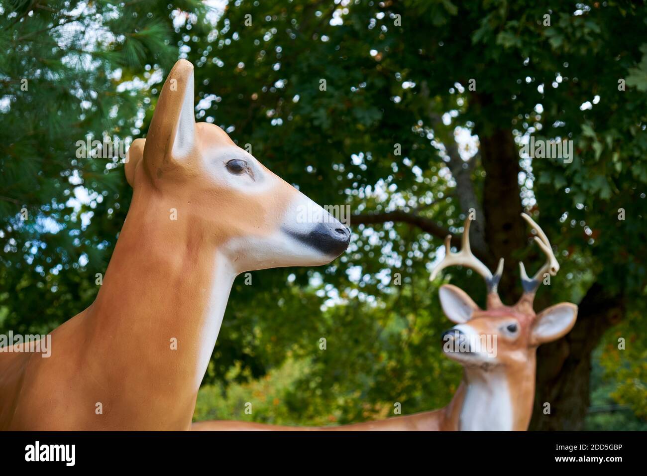 Two plastic, fiberglass, fake deer sculptures, figures, statues, one