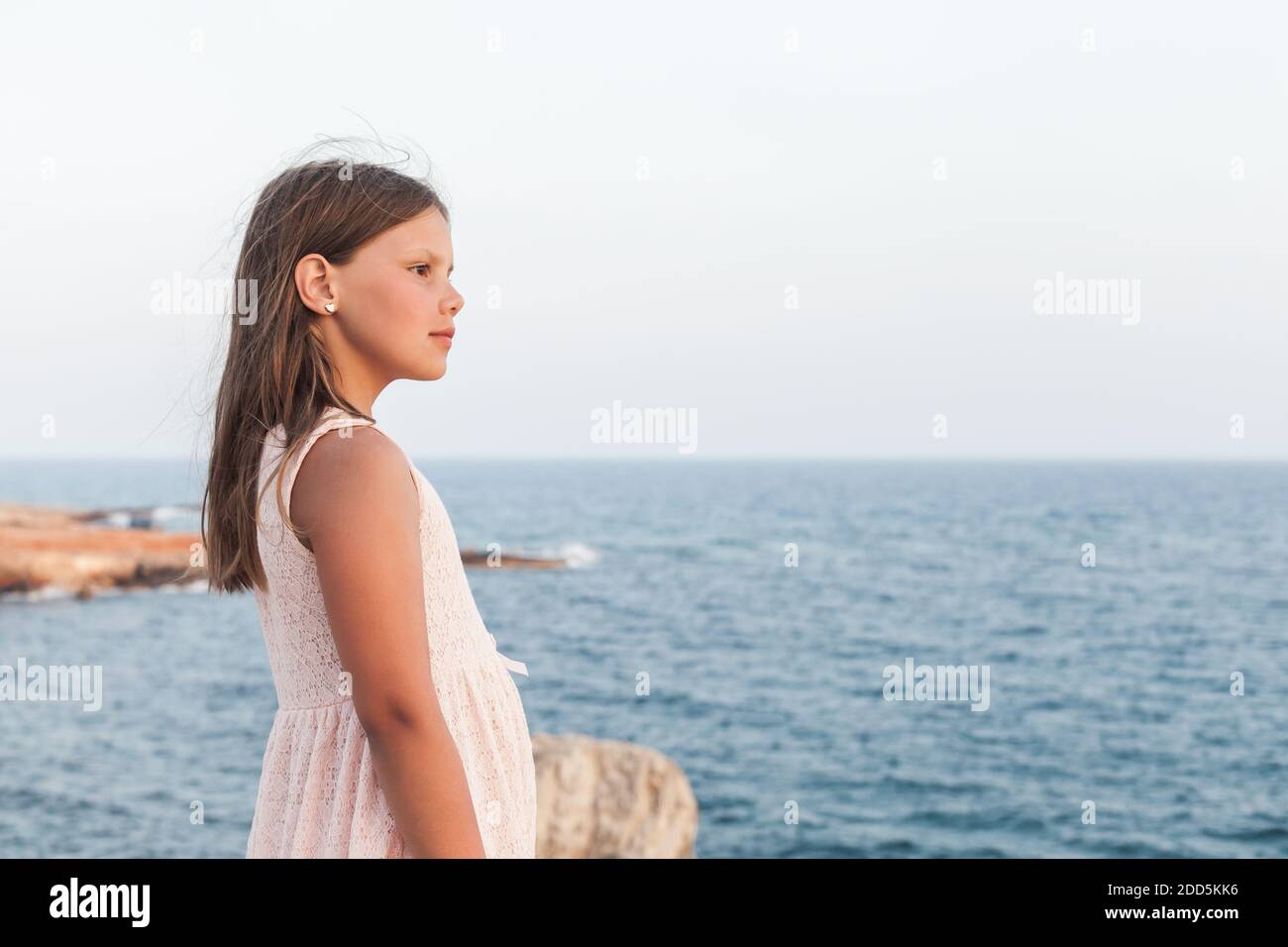 Little girl in white dress starring at the sea, outdoor portrait Stock ...