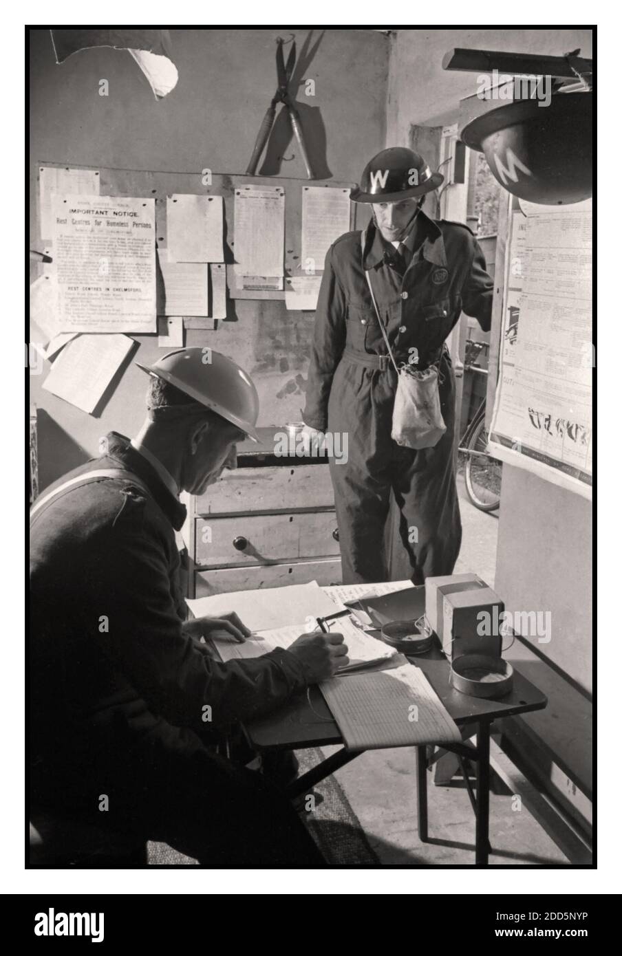 WW2 British Air Raid Precautions Warden reports for duty to the Chief Warden at his local ARP post in Springfield, Essex, AUGUST 1941. An Air Raid Precautions Warden in uniform with helmet reports for duty to the Chief ARP Warden, Mr Davies, at his local ARP post in Springfield, Essex. 1941 Stock Photo