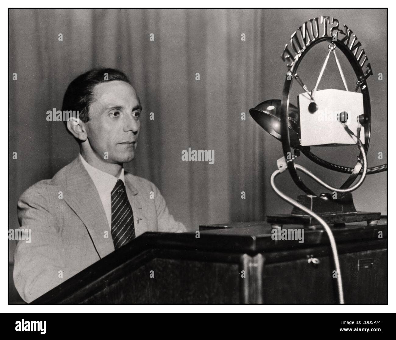 GOEBBELS RADIO BROADCAST 1930's Nazi NSDAP Propaganda Minister Joseph Goebbels with microphone addresses  the German nation by radio broadcast transmission. Goebbels realised that he and Führer Adolf Hitler could reach a wide audience through the medium of radio broadcast “Ganz Deutschland hört den Führer mit dem Volksempfänger”“ All over Germany hear the Führer with the people's radio receiver”   The Volksempfänger, an affordable and extremely popular German radio, was introduced in 1933, the year Adolf Hitler was appointed chancellor of Nazi Germany. Stock Photo