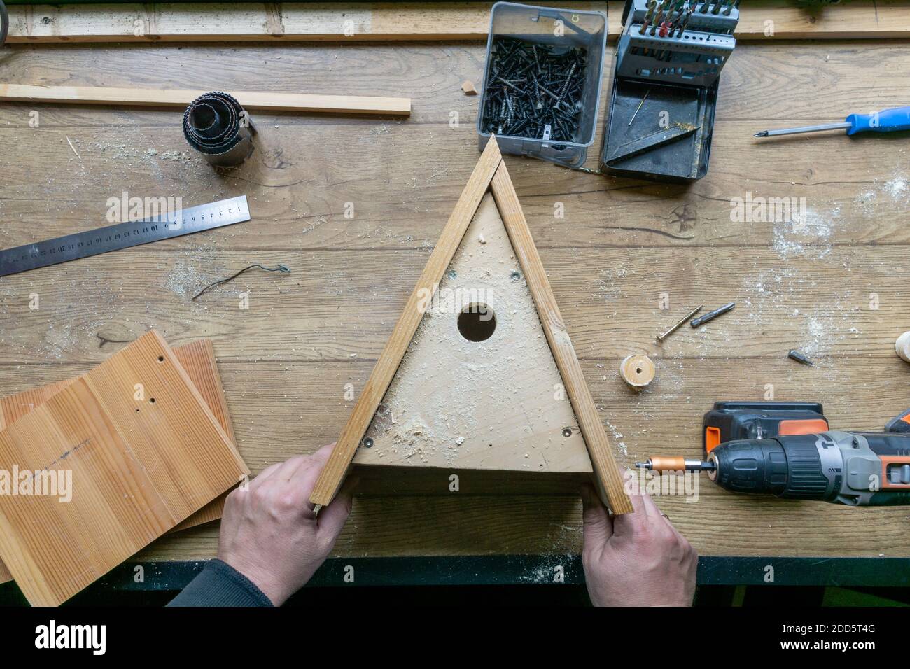 Amateur carpenter with wooden birdhouse. Stock Photo