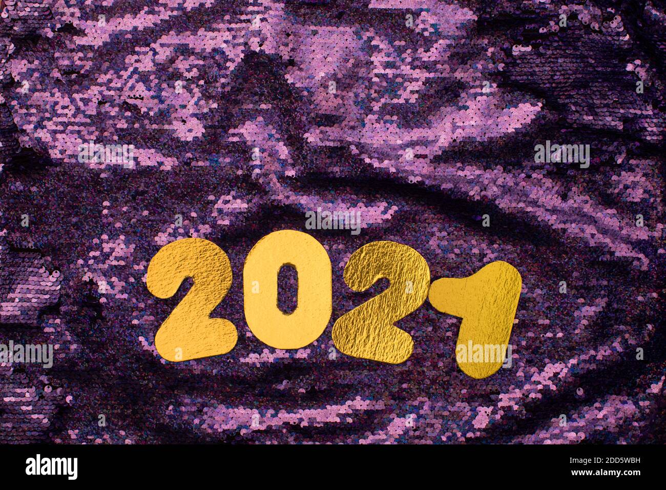 Gold numbers 2021 on sequins glitter purple background. New year celebration. Happy New Year 2021 Stock Photo