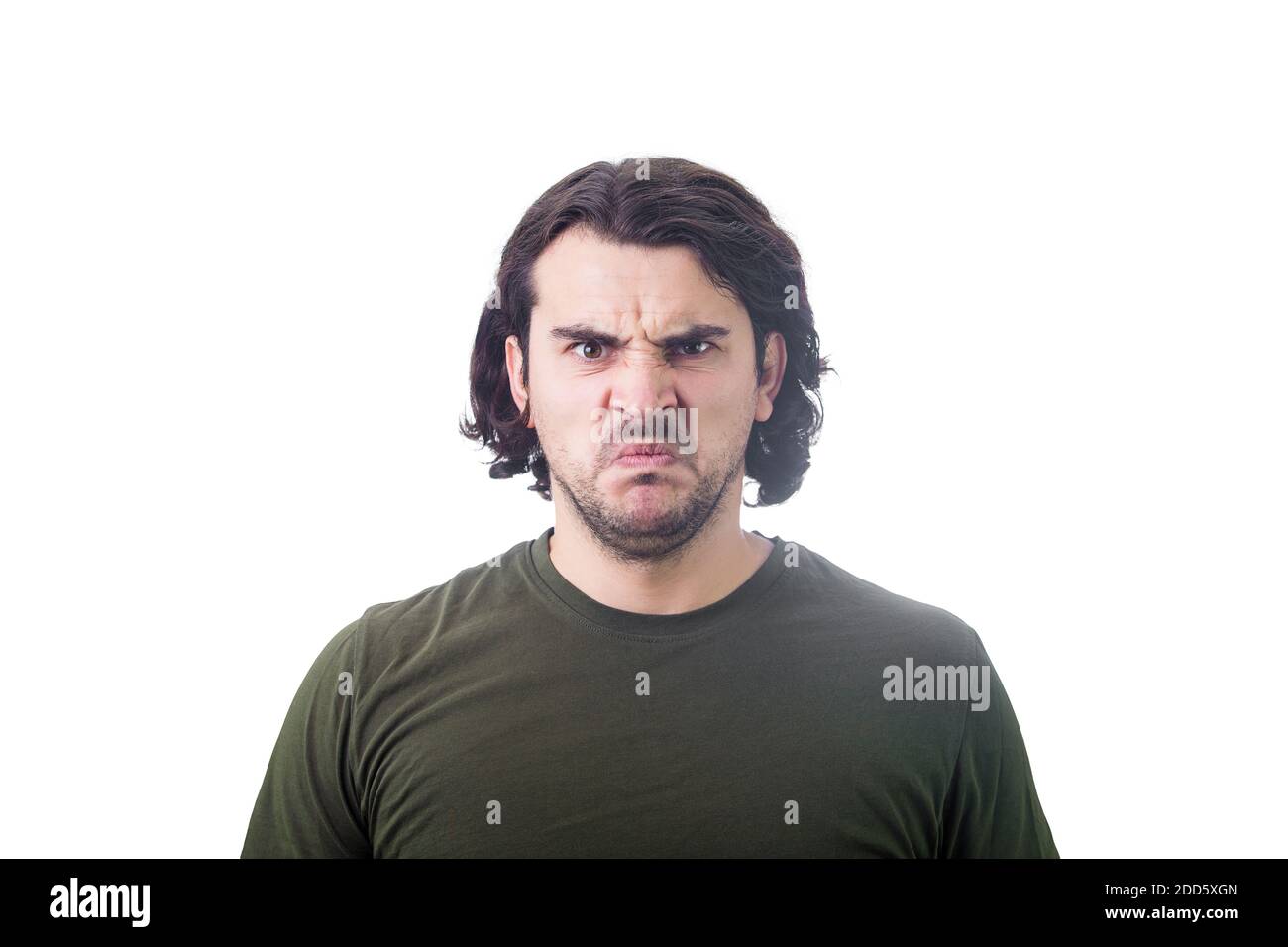 Bewildered and confused young man looking perplexed and upset to camera isolated on white background. Angry casual guy, long curly hair style, irritat Stock Photo