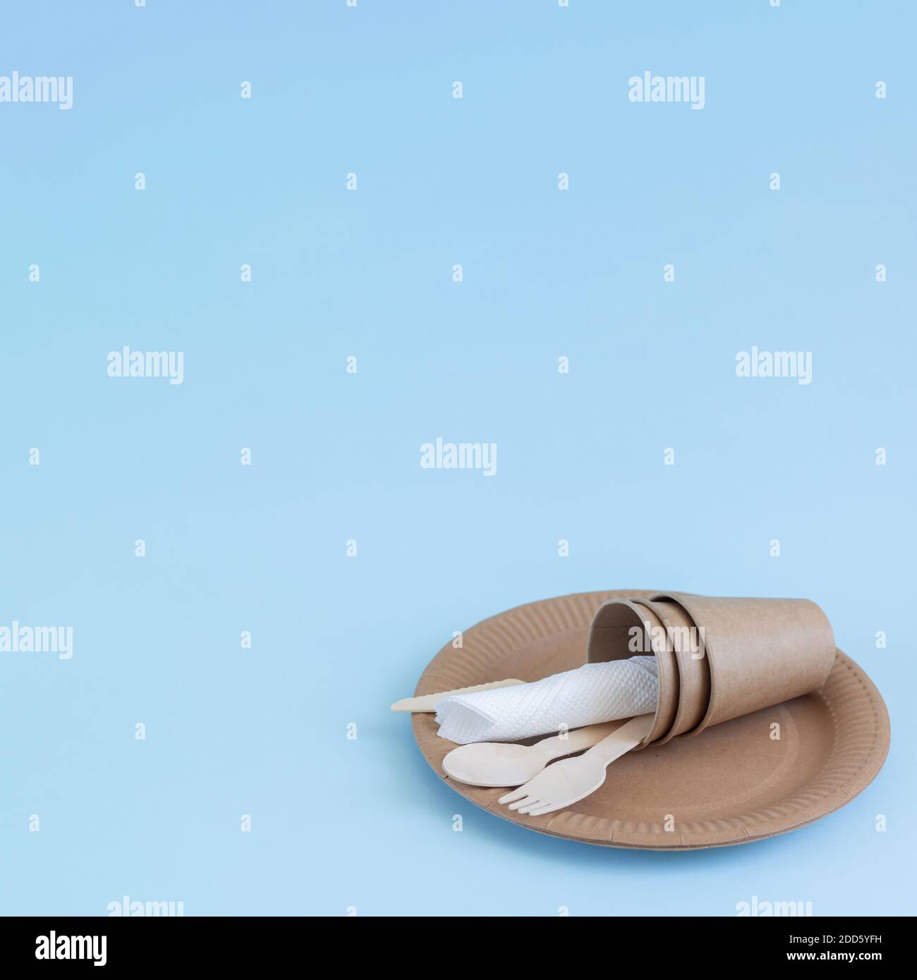 Disposable eco friendly bamboo wood and paper utensils on blue background. Space for your text Stock Photo