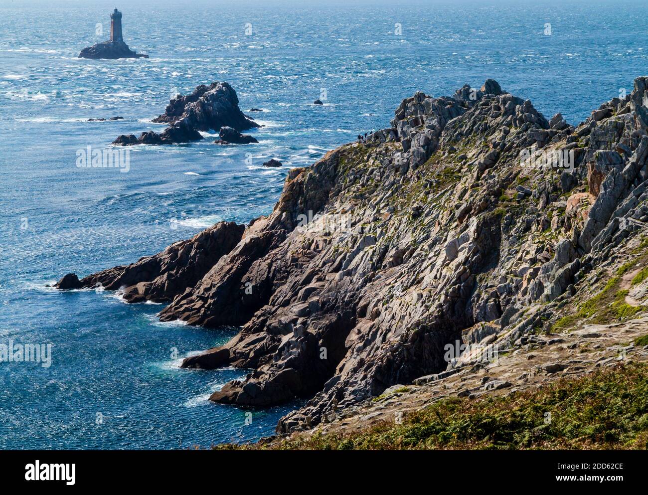 Rocky headland and lighthouse at the Pointe du Raz near Plogoff in Finistere Brittany north west France. Stock Photo