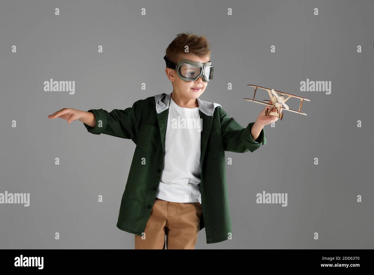 happy child boy in retro glasses playing with wooden toy airplane on ...