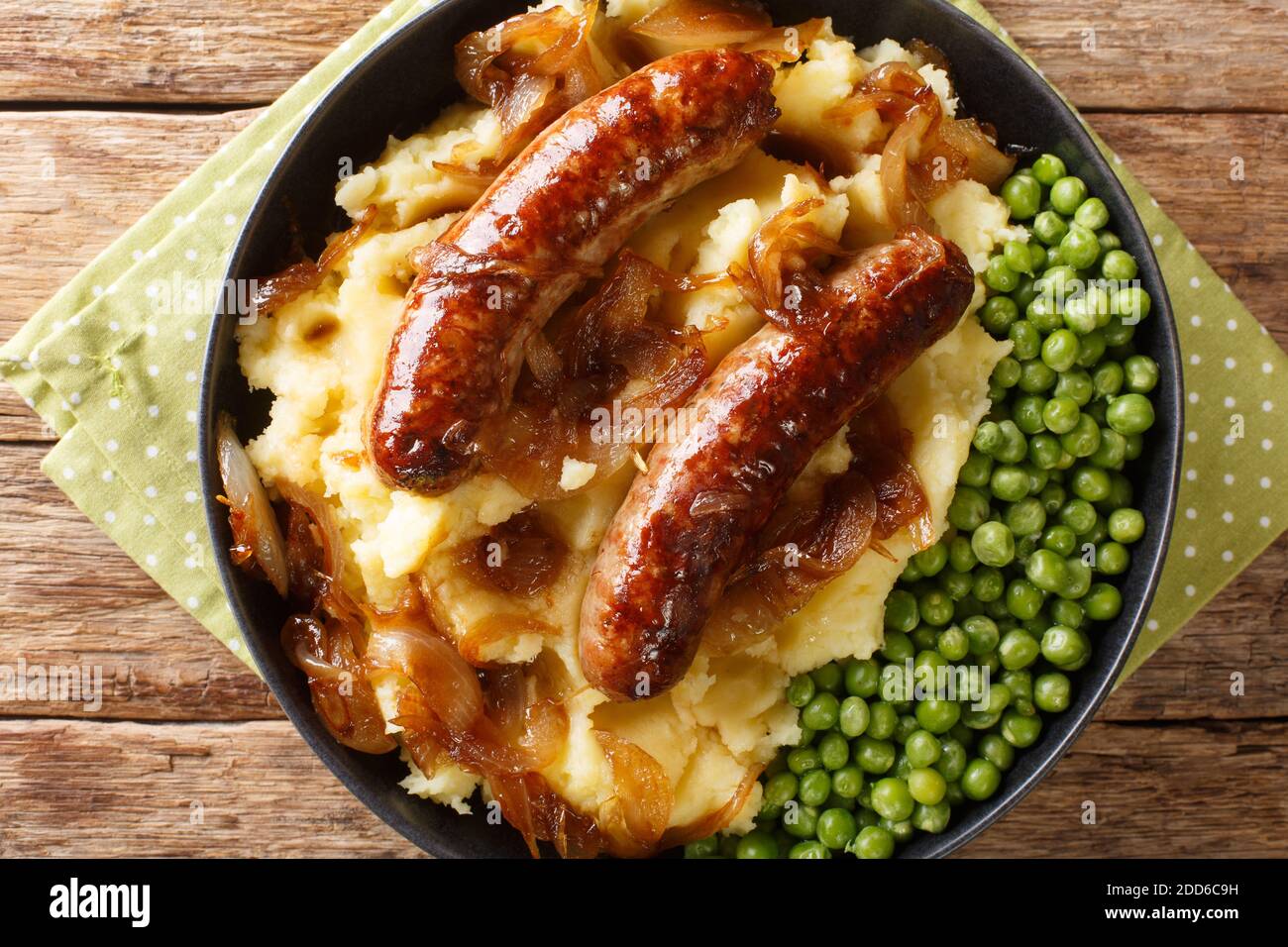 Irish Bangers and Mash is a dish consisting of sausages served with mashed potatoes and onion gravy closeup in the plate on the table. horizontal top Stock Photo