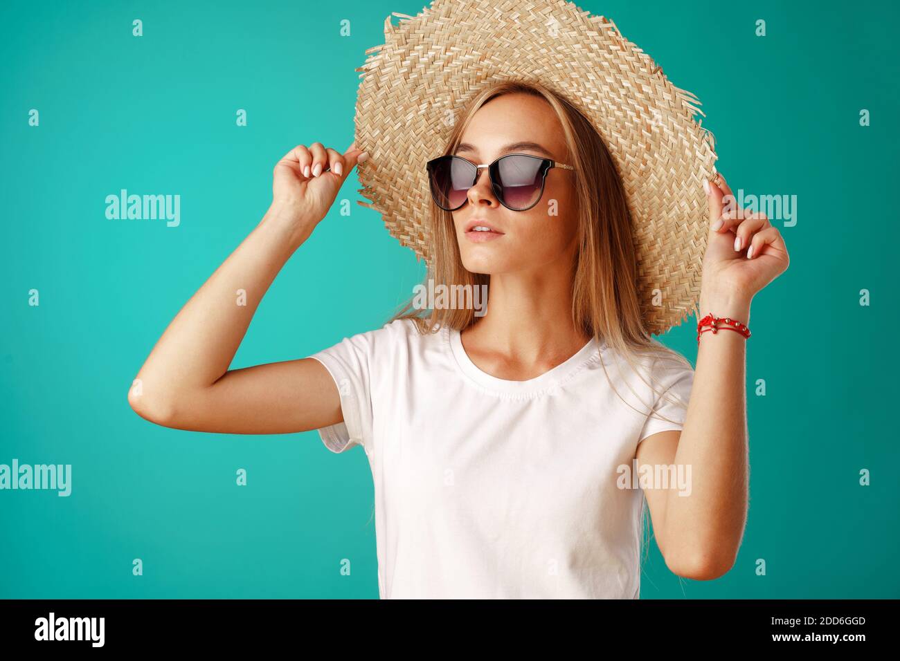 Beautiful blonde woman model posing in a straw hat Stock Photo - Alamy
