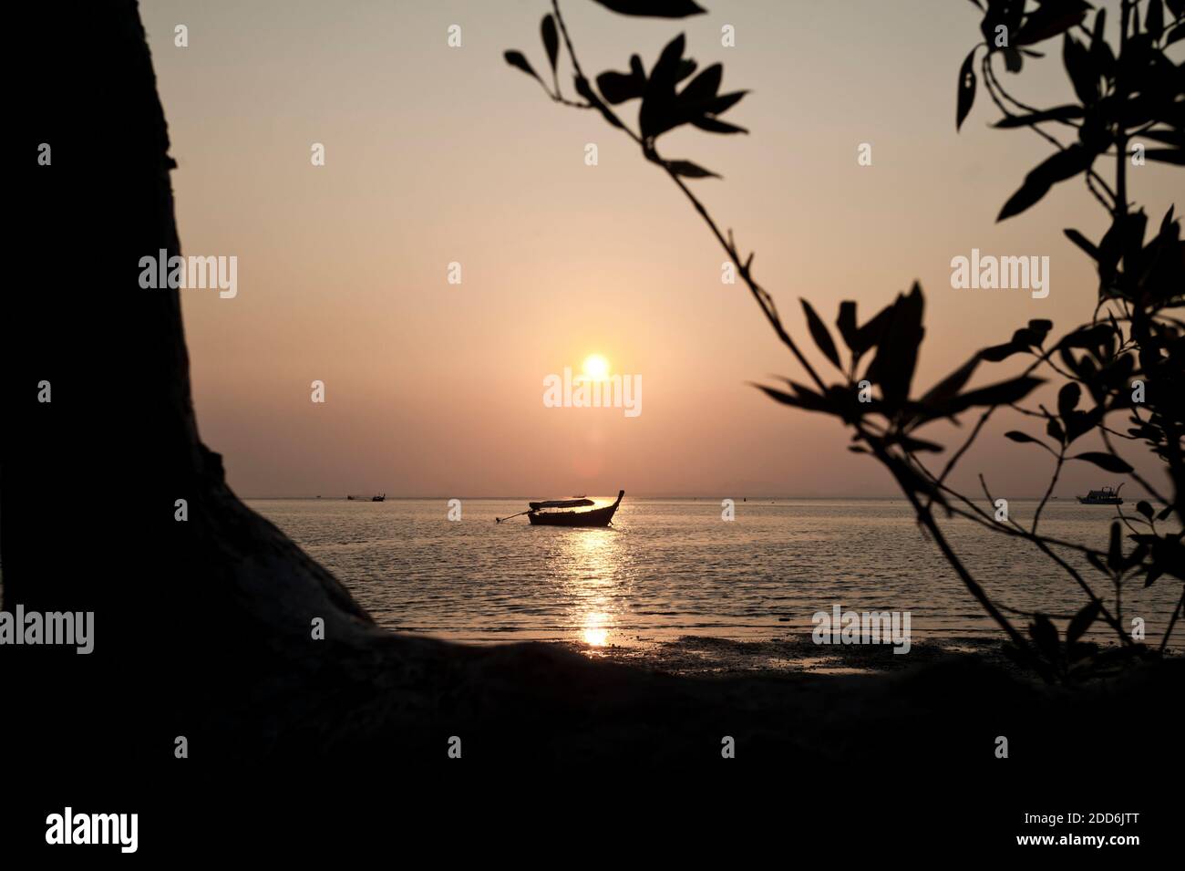 Traditional Thai Boat Silhouetted at Sunrise at Popular East Railay Beach, South Thailand, Southeast Asia Stock Photo