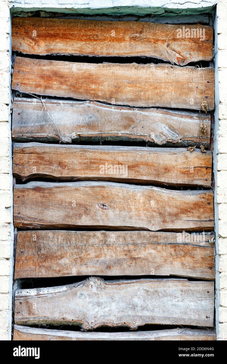 Close-up of a boarded up window opening, weathered board texture, image with copy space. Stock Photo