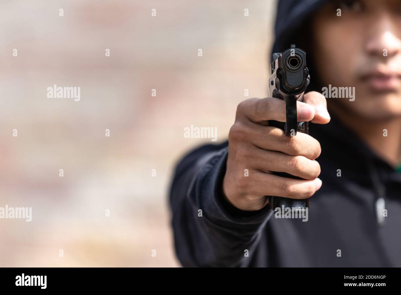 The gangster aimed a gun at the camera. A thief pointing a gun at the target. selective focus on the front gun, Blurred focus. Stock Photo
