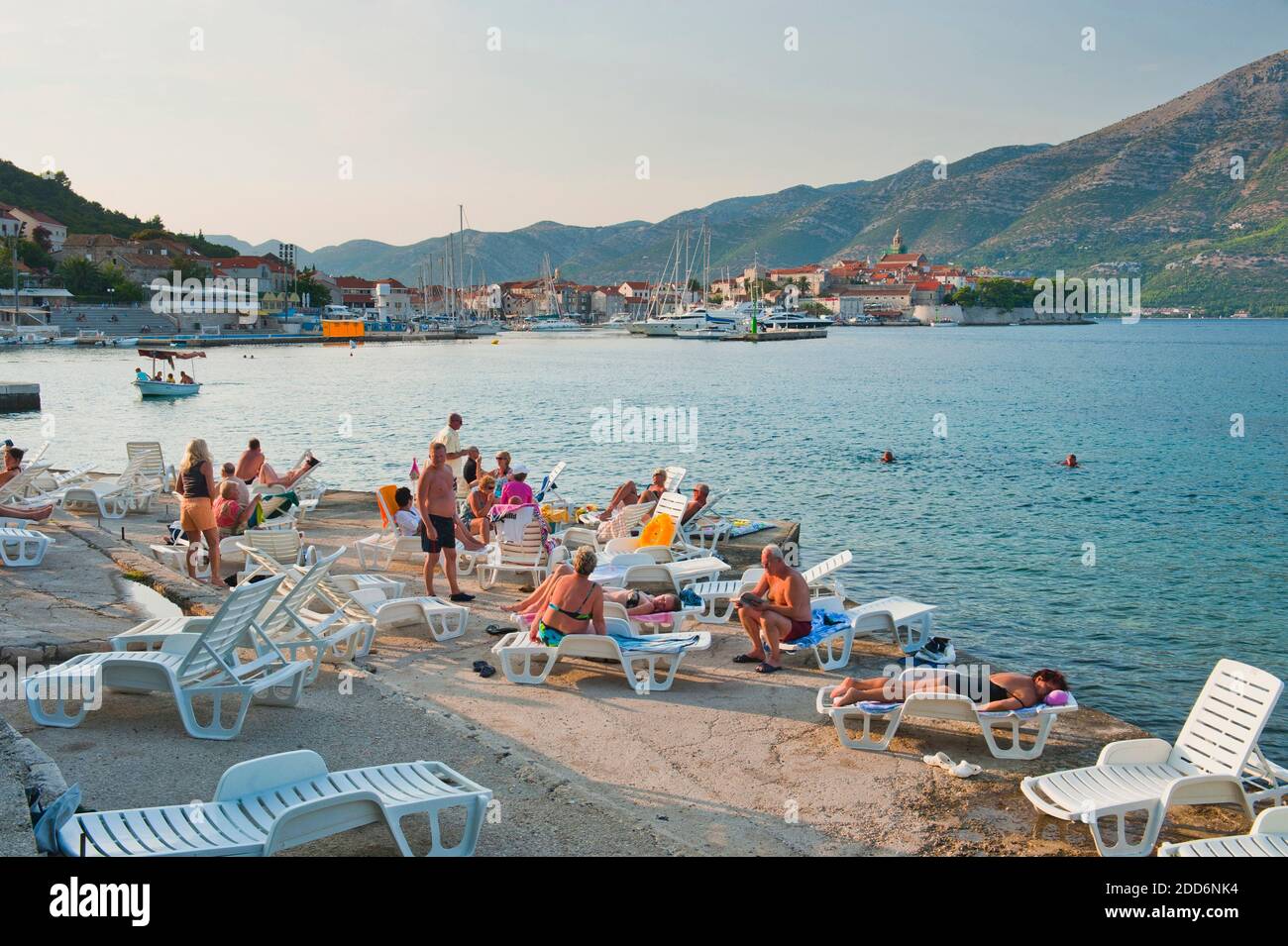 Tourists sunbathing in Korcula Town, Korcula Island, Dalmatia (Dalmacija), Croatia Stock Photo