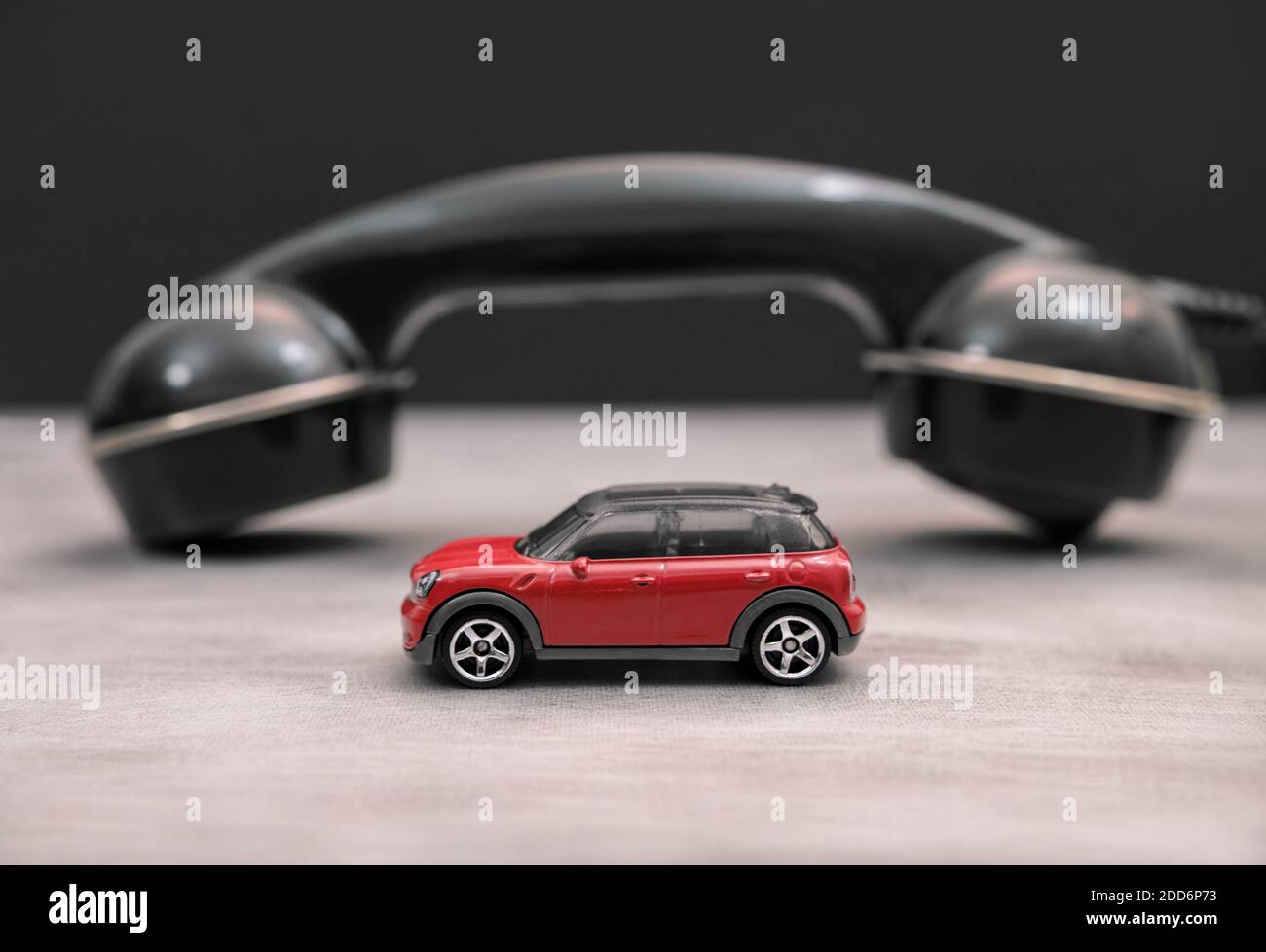 A small Mini (toy) car and a old telephone receiver in the background ...