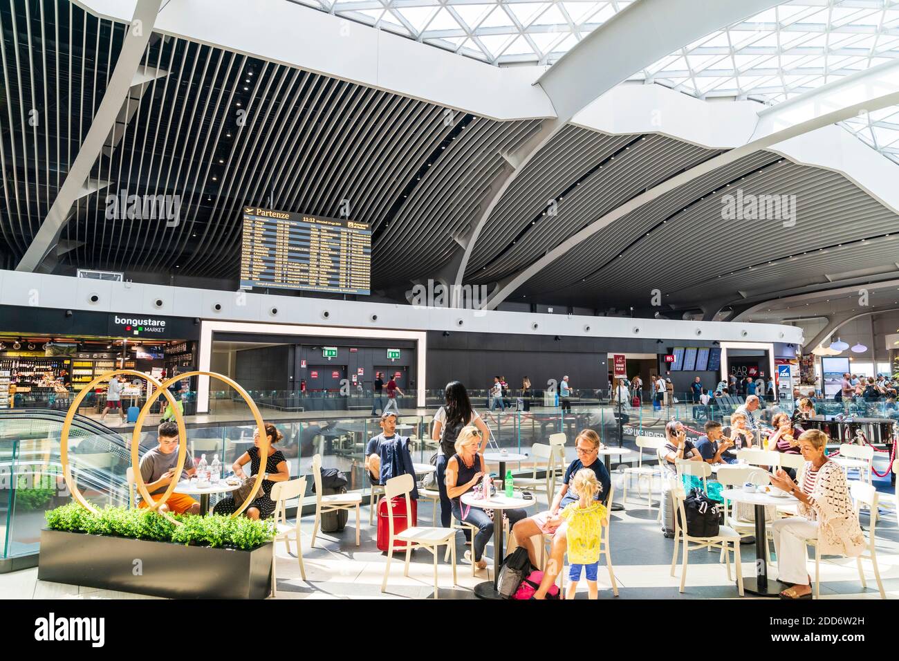 Interior of the E2nd floor of the departure area of Leonardo da Vinci - Fiumicino Rome airport, people sitting at tables outside cafe (unseen). Stock Photo